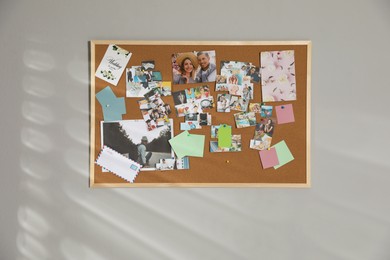 Vision board with different photos representing dreams on grey wall