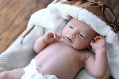 Cute newborn baby in aviator hat on blanket, closeup