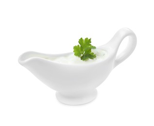 Ceramic sauce boat with sour cream and parsley isolated on white