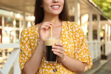Young woman with cold kvass outdoors, closeup. Traditional Russian summer drink