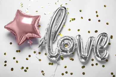 Foil star shaped and LOVE balloons on white background, above view