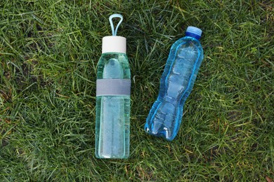 Photo of Bottles of fresh water on green grass outdoors, flat lay