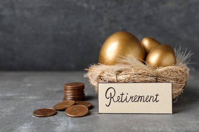Many golden eggs, coins and card with word Retirement on grey table. Pension concept