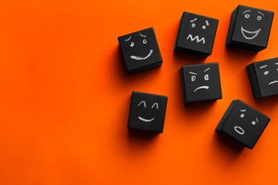 Photo of Many cubes with different emotions on orange background, flat lay and space for text. Emotional management
