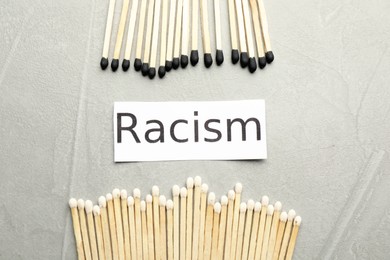 Word Racism and different matches on light grey table, flat lay
