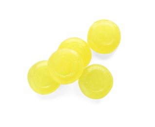 Many yellow cough drops on white background, top view