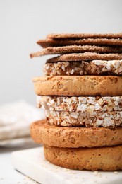 Stack of rye crispbreads, rice cakes and rusks on table, closeup