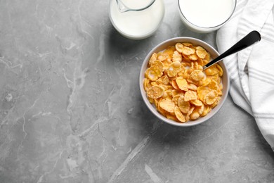 Tasty cornflakes with milk served on grey marble table, flat lay. Space for text