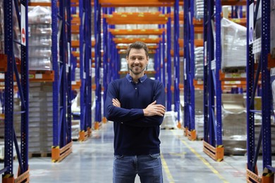 Happy manager in warehouse with lots of products