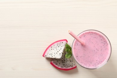 Delicious pitahaya smoothie with mint and fresh fruit on white wooden table, flat lay. Space for text