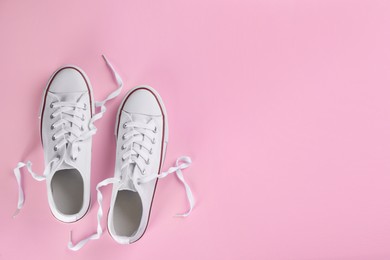 Photo of Pair of trendy sneakers on pink background, flat lay. Space for text