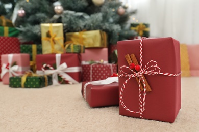 Beautiful Christmas gift and blurred pile of presents on background. Space for text