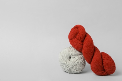 Soft woolen yarns on white background, space for text