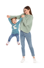 Photo of Young mother with little daughter having fun on white background