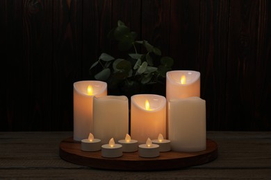 Beautiful decorative LED candles on wooden table