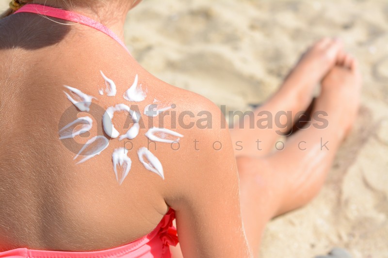 Photo of Little girl with sun protection cream on back outdoors, closeup. Space for text