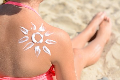 Little girl with sun protection cream on back outdoors, closeup. Space for text