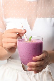 Woman with glass of delicious blackberry smoothie, closeup