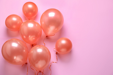 Colorful balloons on pink background, flat lay. Space for text