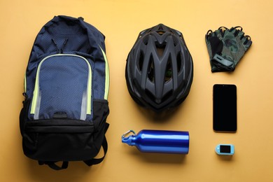 Flat lay composition with different cycling accessories on pale orange background