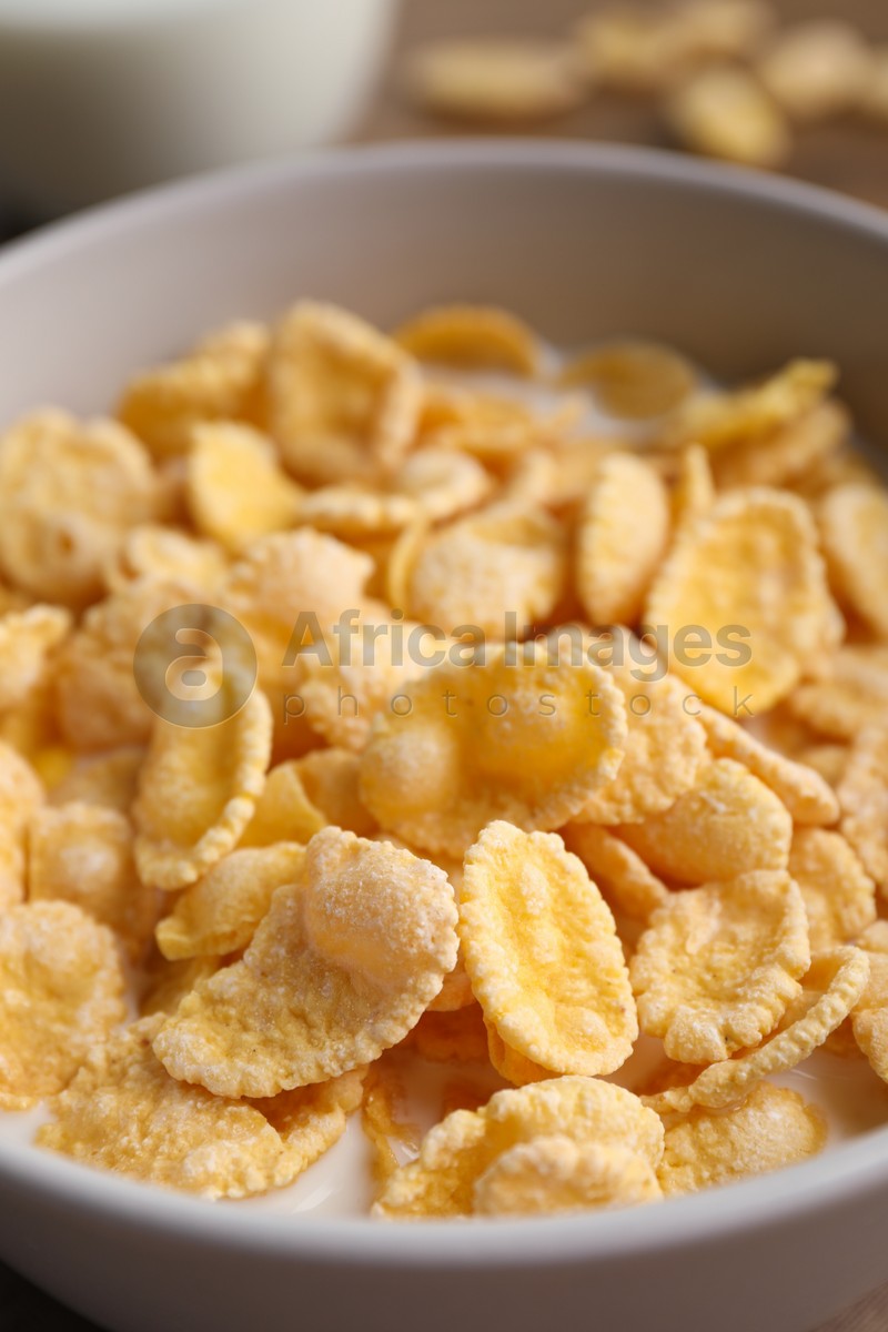 Tasty cornflakes with milk in bowl, closeup