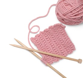 Soft pink woolen yarn, knitting and wooden needles on white background, top view