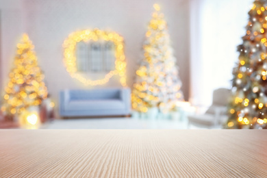 Empty wooden surface and blurred view of room decorated for Christmas