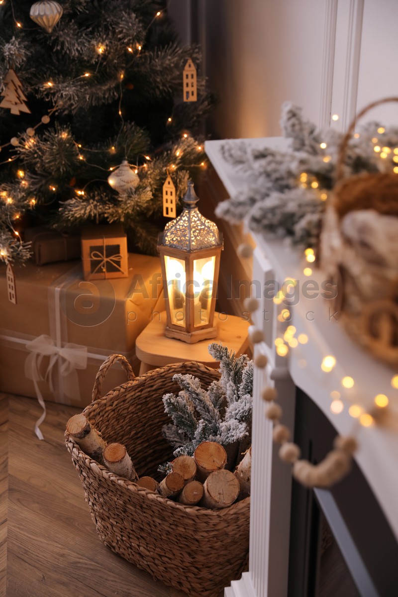 Basket with wood near fireplace and Christmas tree indoors. Interior element