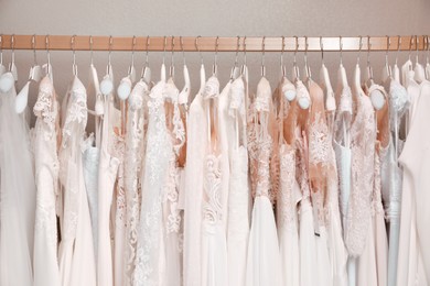 Photo of Different wedding dresses on hangers in boutique
