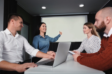 Business people having meeting in conference room with video projection screen