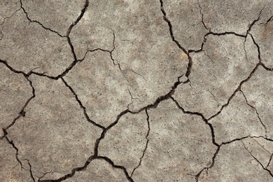 Dry textured ground surface as background, top view. Thirsty soil