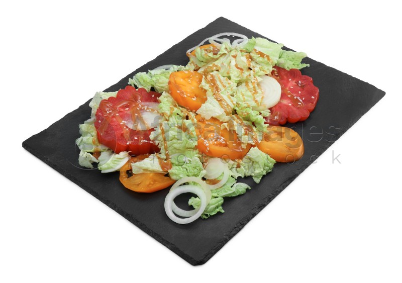 Slate plate of delicious salad with Chinese cabbage, tomatoes and onion on white background