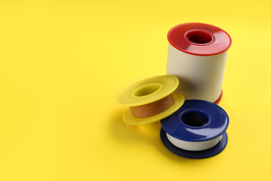 Sticking plaster rolls on yellow background. Space for text
