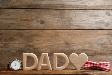 Composition with word DAD and heart on wooden background, space for text. Happy Father's day