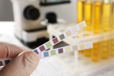 Photo of Nurse holding test strips in laboratory, closeup. Urine analysis