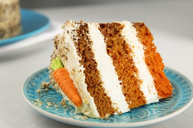 Plate with piece of tasty carrot cake on light table, closeup