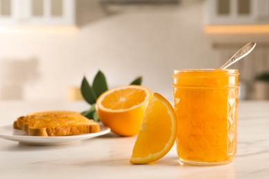 Delicious orange marmalade and citrus fruit slice on white table. Space for text