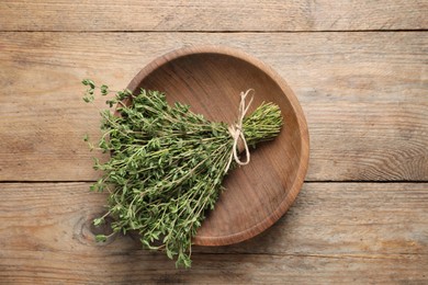Bunch of aromatic thyme on wooden table, top view