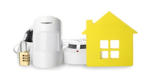 House model, CCTV camera, lock, smoke and movement detectors on white background. Home security system
