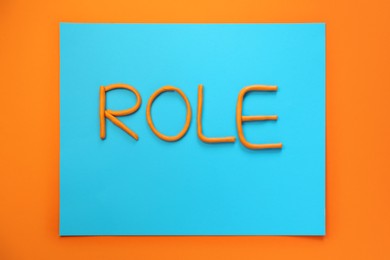 Word Role made with plasticine on orange background, flat lay