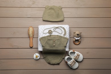 Flat lay composition with cute baby knitwear for photoshoot on wooden background