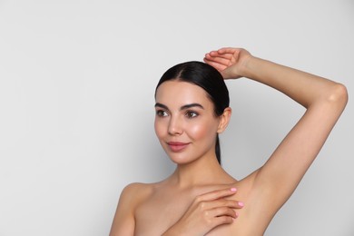 Young woman showing smooth skin after epilation on white background, space for text