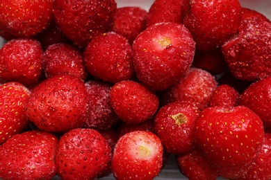 Photo of Pile of frozen strawberries as background, closeup