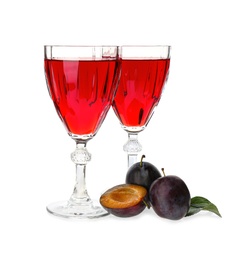 Delicious plum liquor and ripe fruits on white background. Homemade strong alcoholic beverage