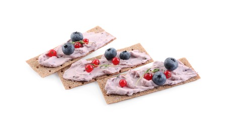 Tasty cracker sandwiches with cream cheese, blueberries, red currants and thyme on white background