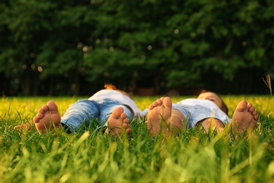 Happy children lying on grass in park