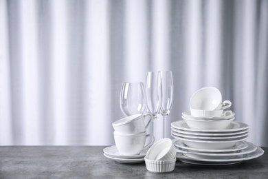 Set of clean dishware on grey table