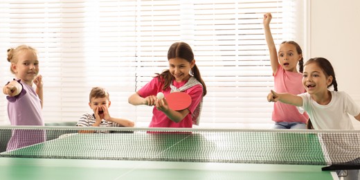 Cute happy children playing ping pong indoors. Banner design