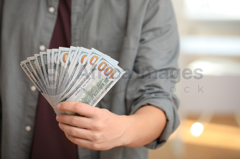Man with American money on blurred background, closeup