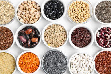 Various raw veggie seeds in bowls on white background, top view